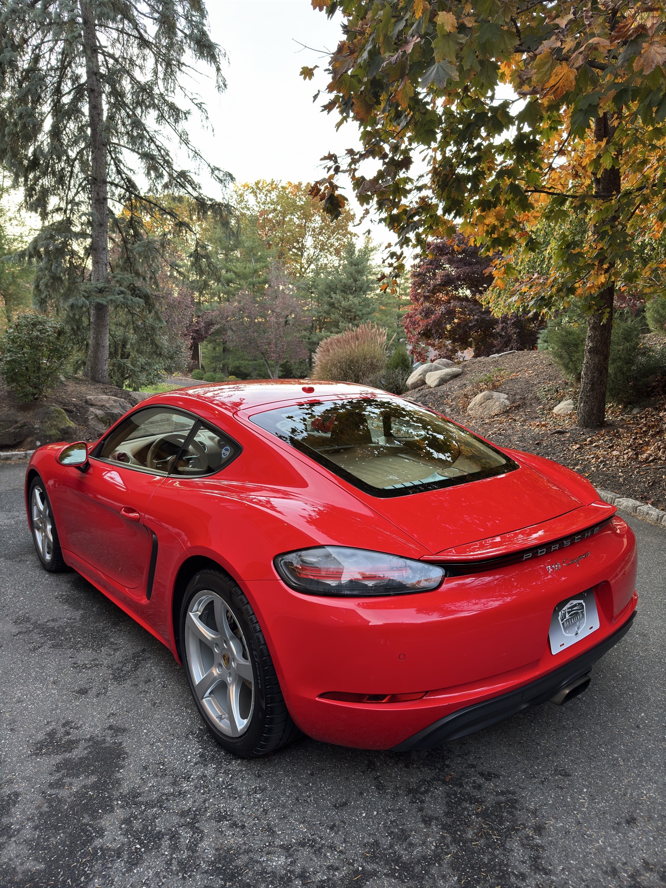Red Porsche 718 Cayman rear three-quarter view after detailing