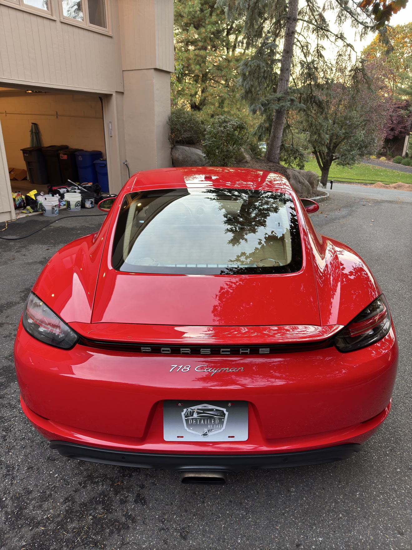 Rear view of a red Porsche 718 Cayman with Detailed by Yael plate frame