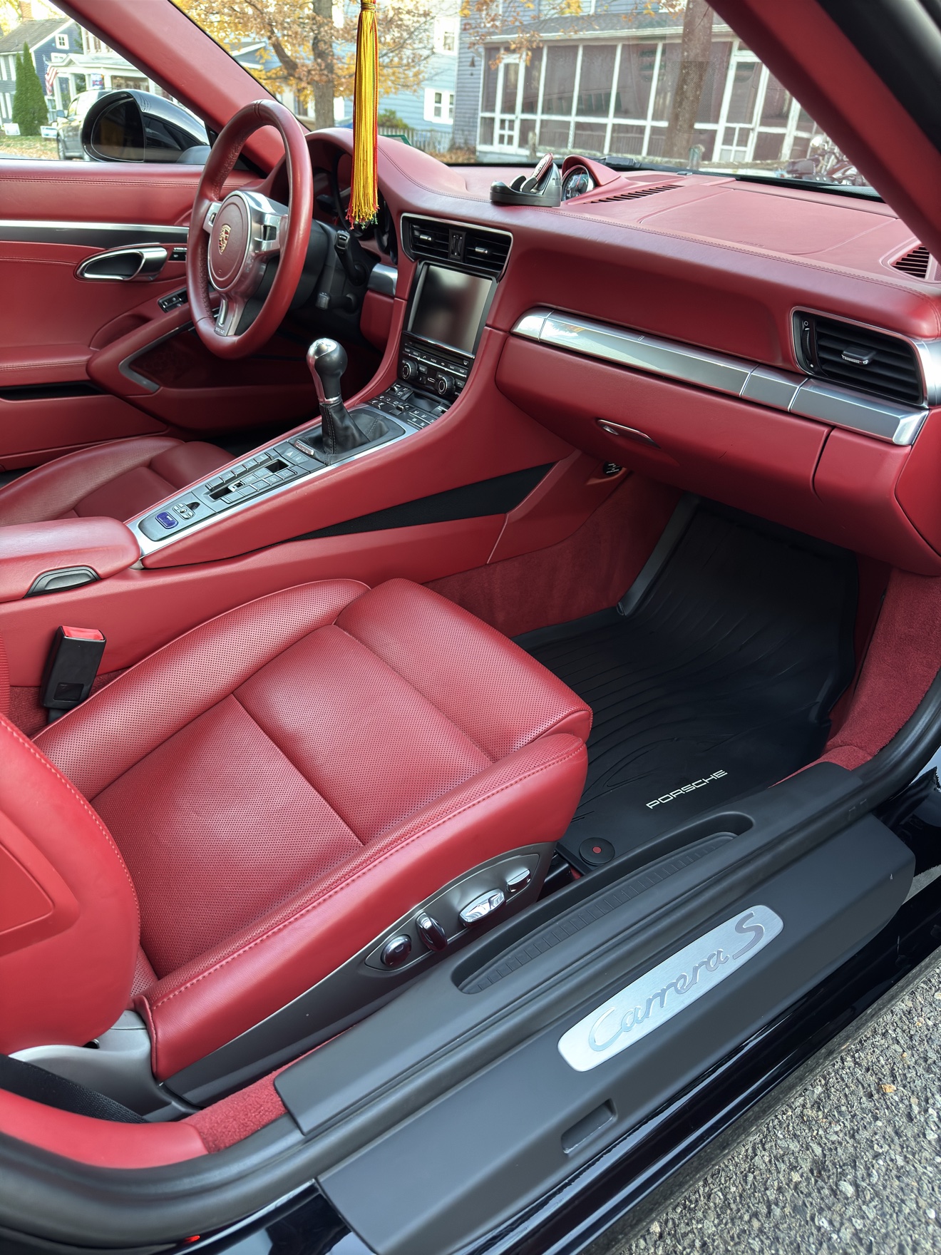 Porsche 911 Carrera S cockpit with red leather seats and manual shifter
