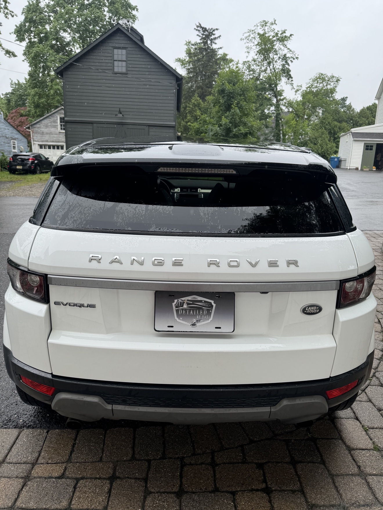Rear view of a white Range Rover Evoque with Detailed by Yael plate frame