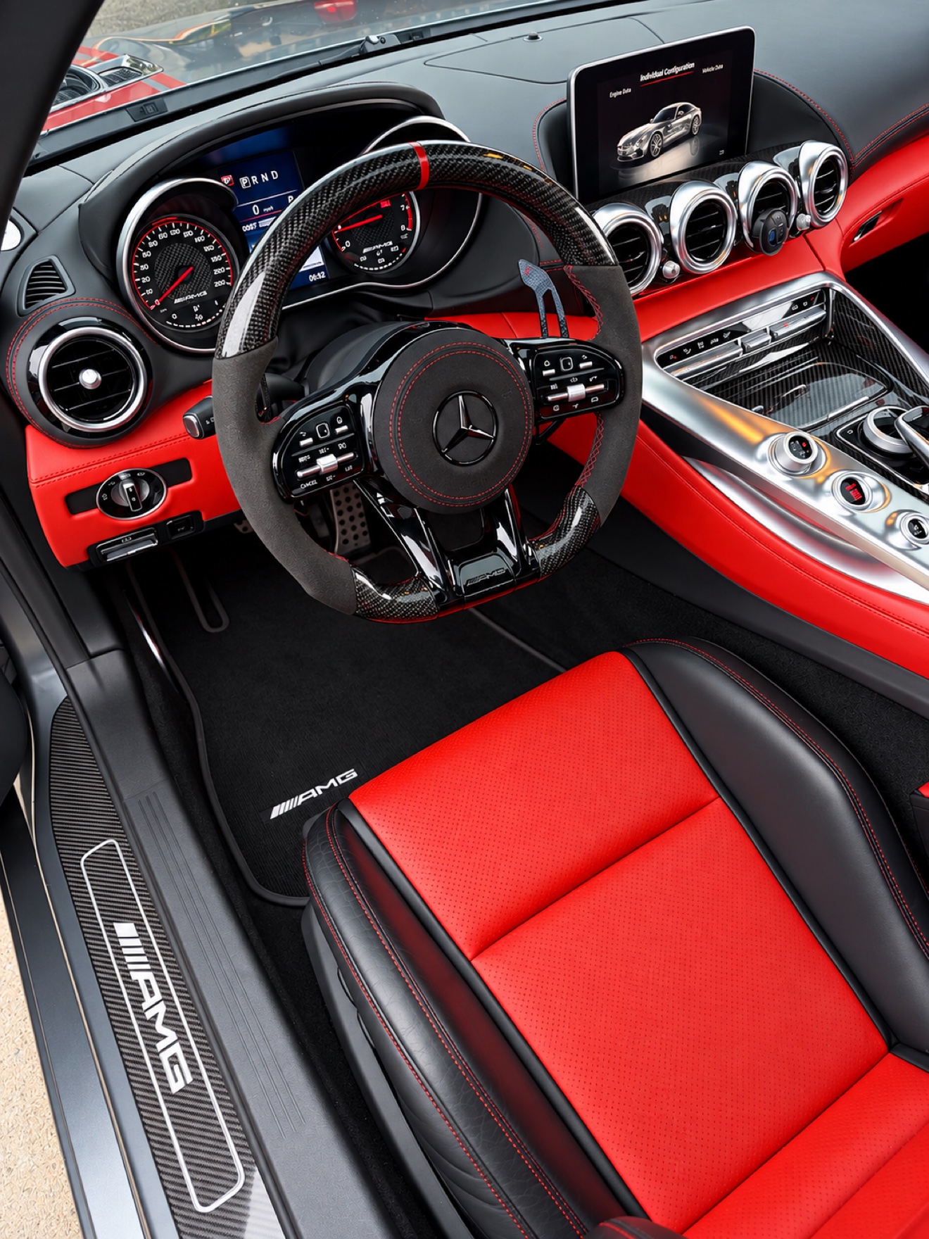 Mercedes AMG GT interior with red and black leather, carbon steering wheel and AMG sill plate