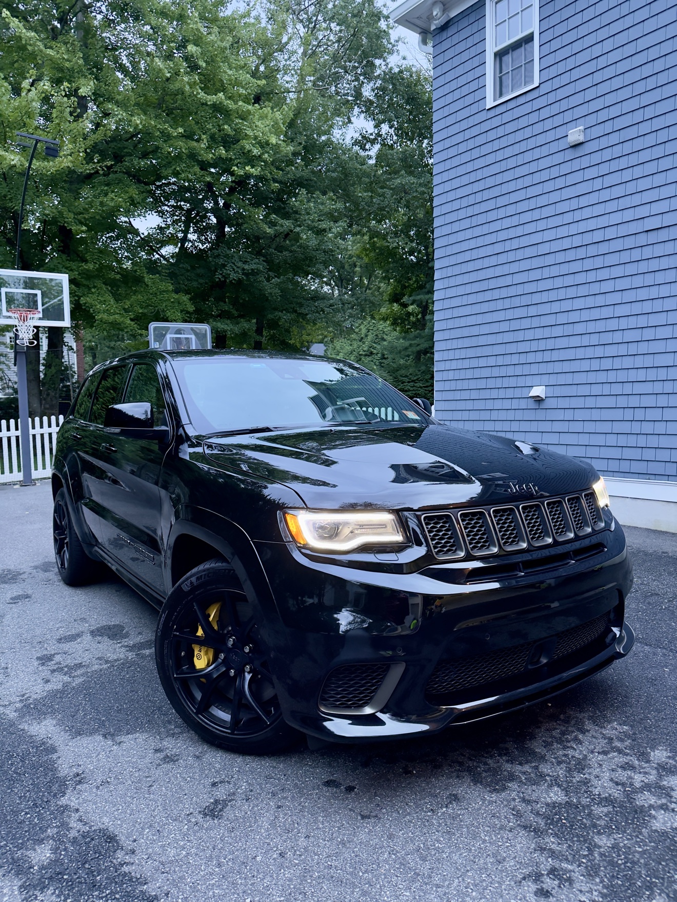Black Jeep Grand Cherokee Trackhawk front three-quarter view with headlights on after detailing