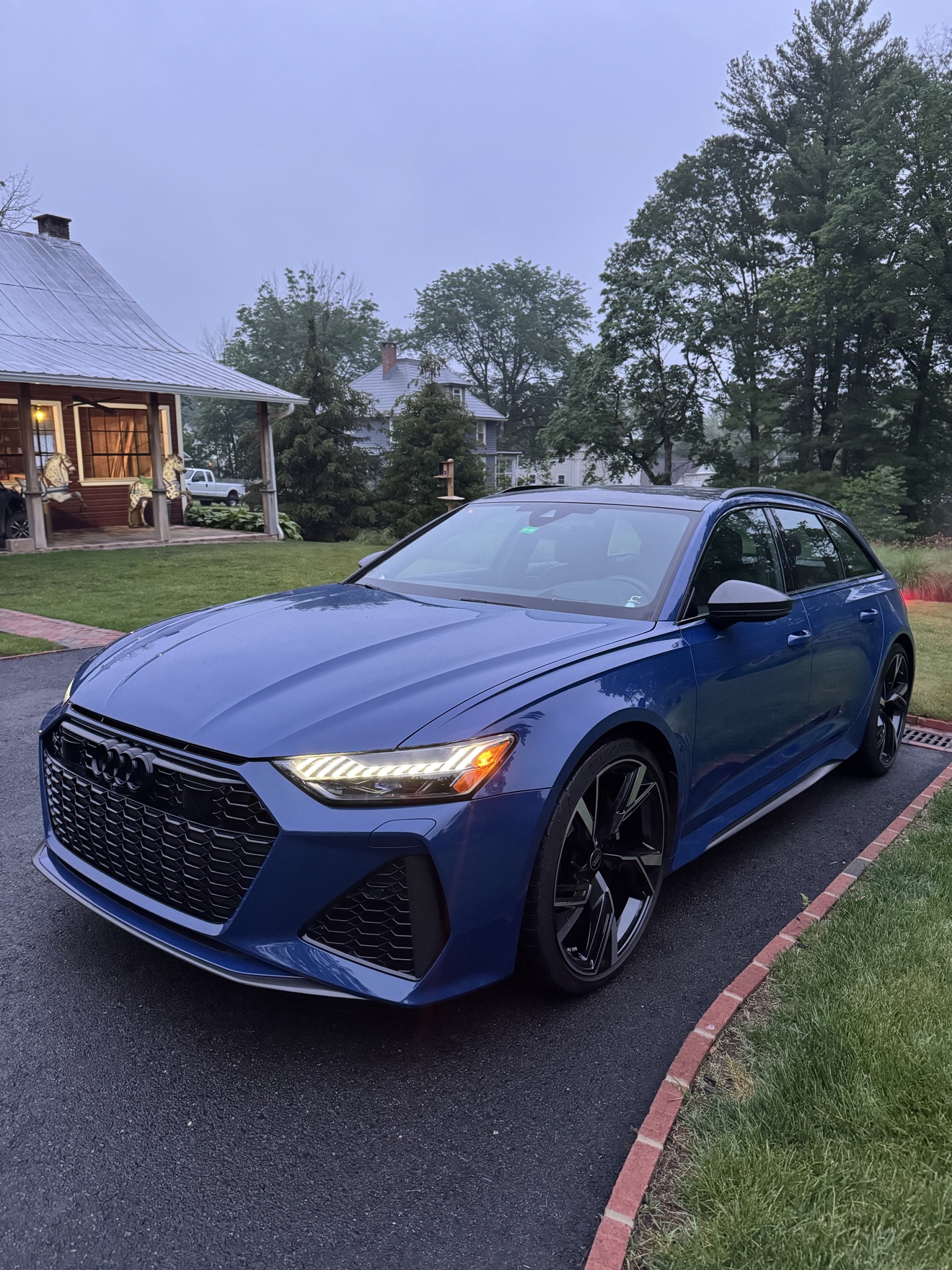 Blue Audi RS6 Avant front angle view in a driveway after detailing