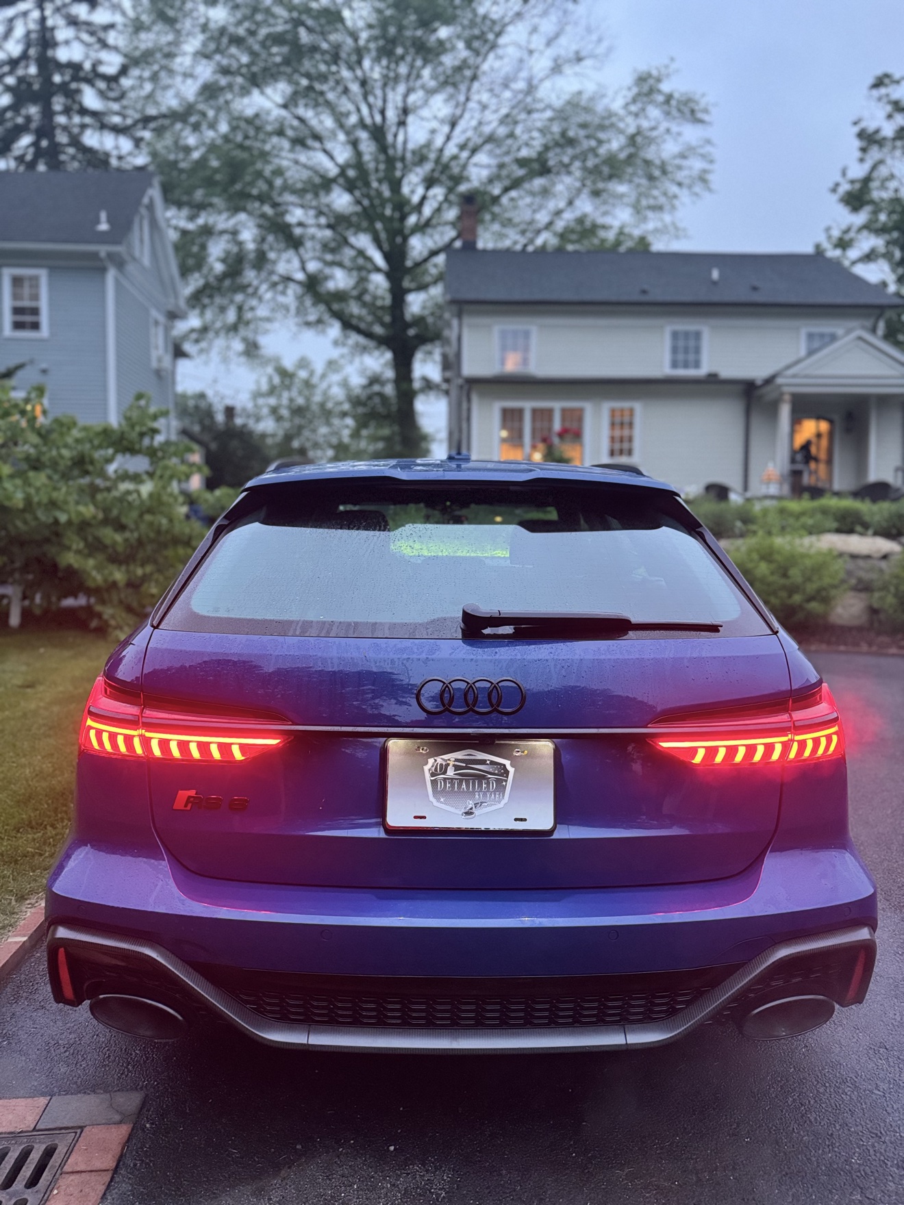 Rear view of a blue Audi RS6 Avant with RS 6 badge and Detailed by Yael plate frame