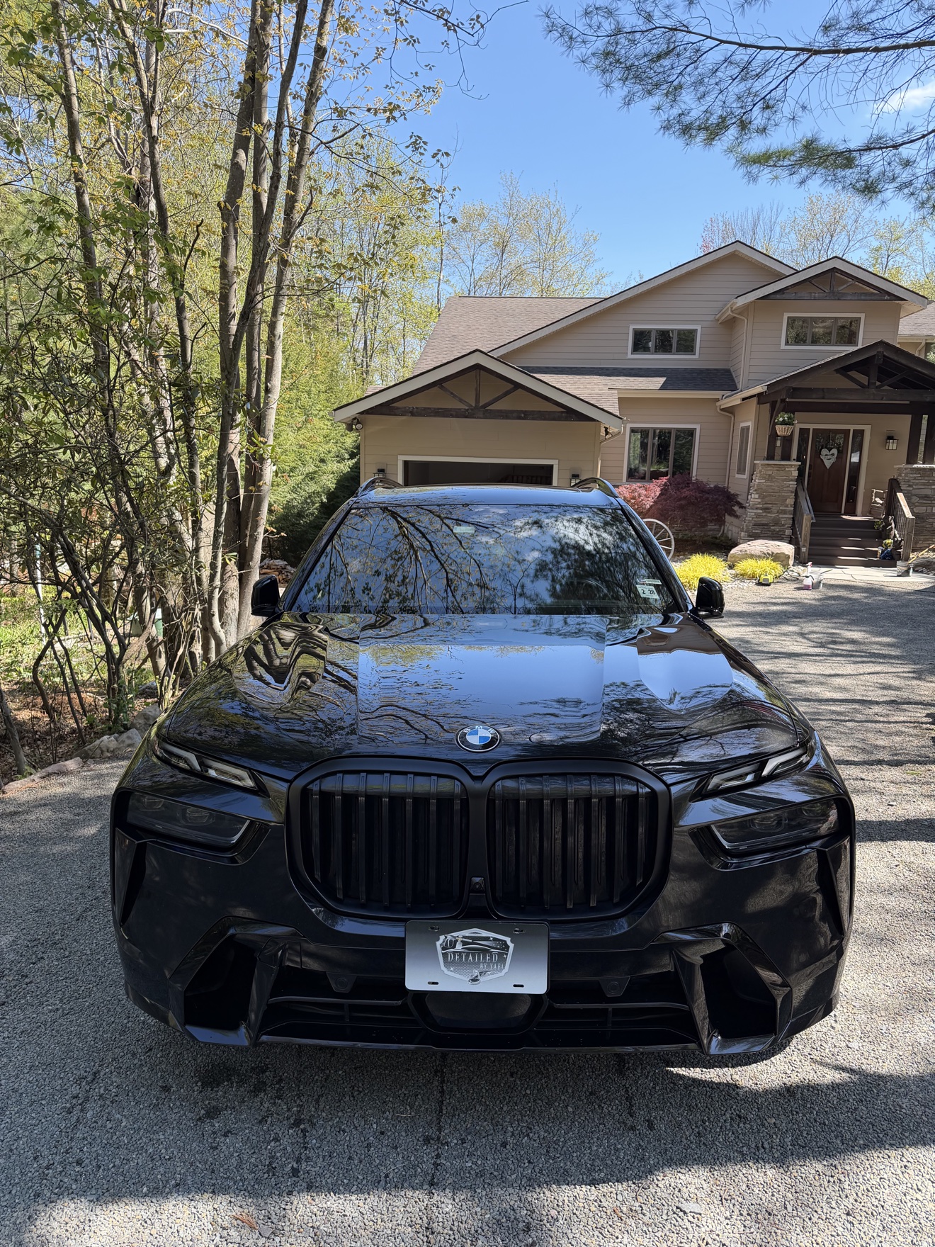 Front view of a black BMW X7 with Detailed by Yael plate frame