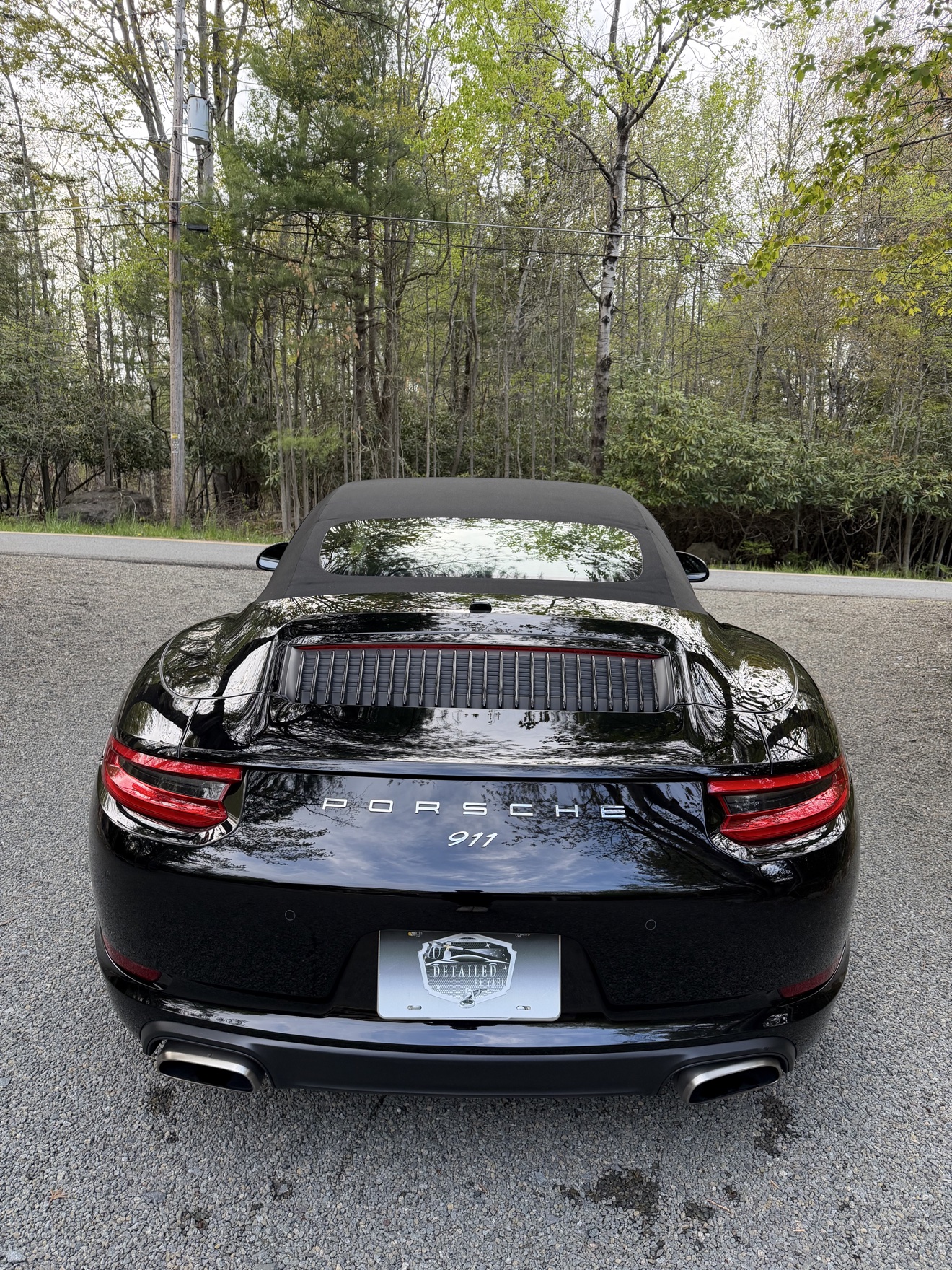 Rear view of a black Porsche 911 Carrera Cabriolet with PORSCHE 911 badging
