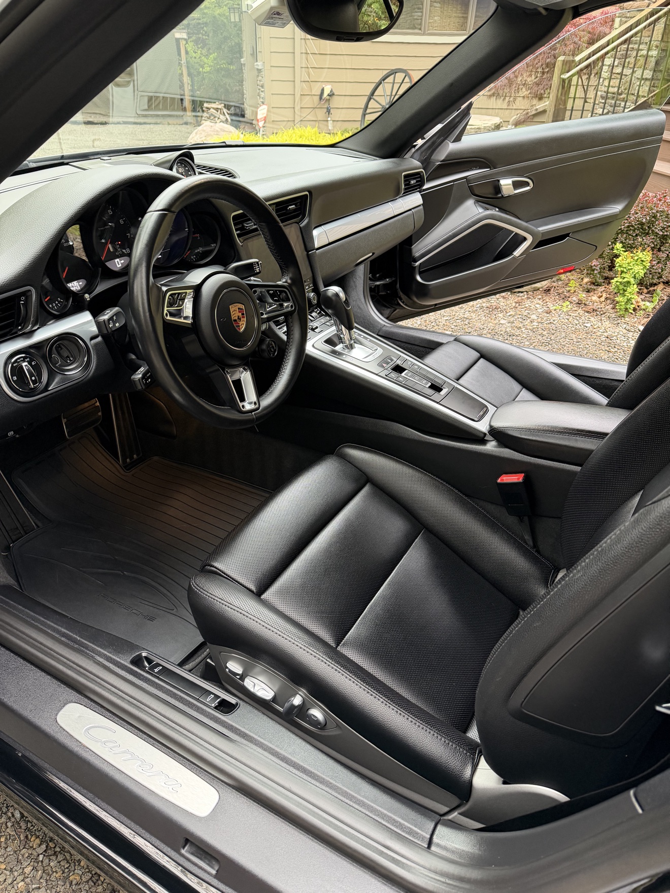 Porsche 911 Carrera driver cockpit with black leather seats and Carrera sill plate