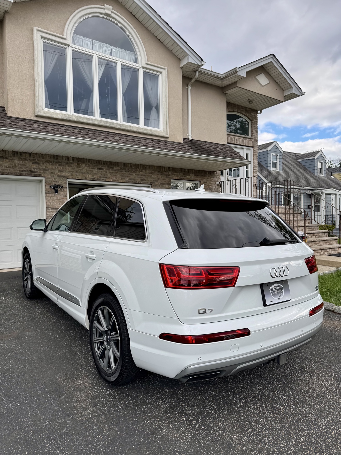 White Audi Q7 rear three-quarter view with Q7 badge and Detailed by Yael plate frame