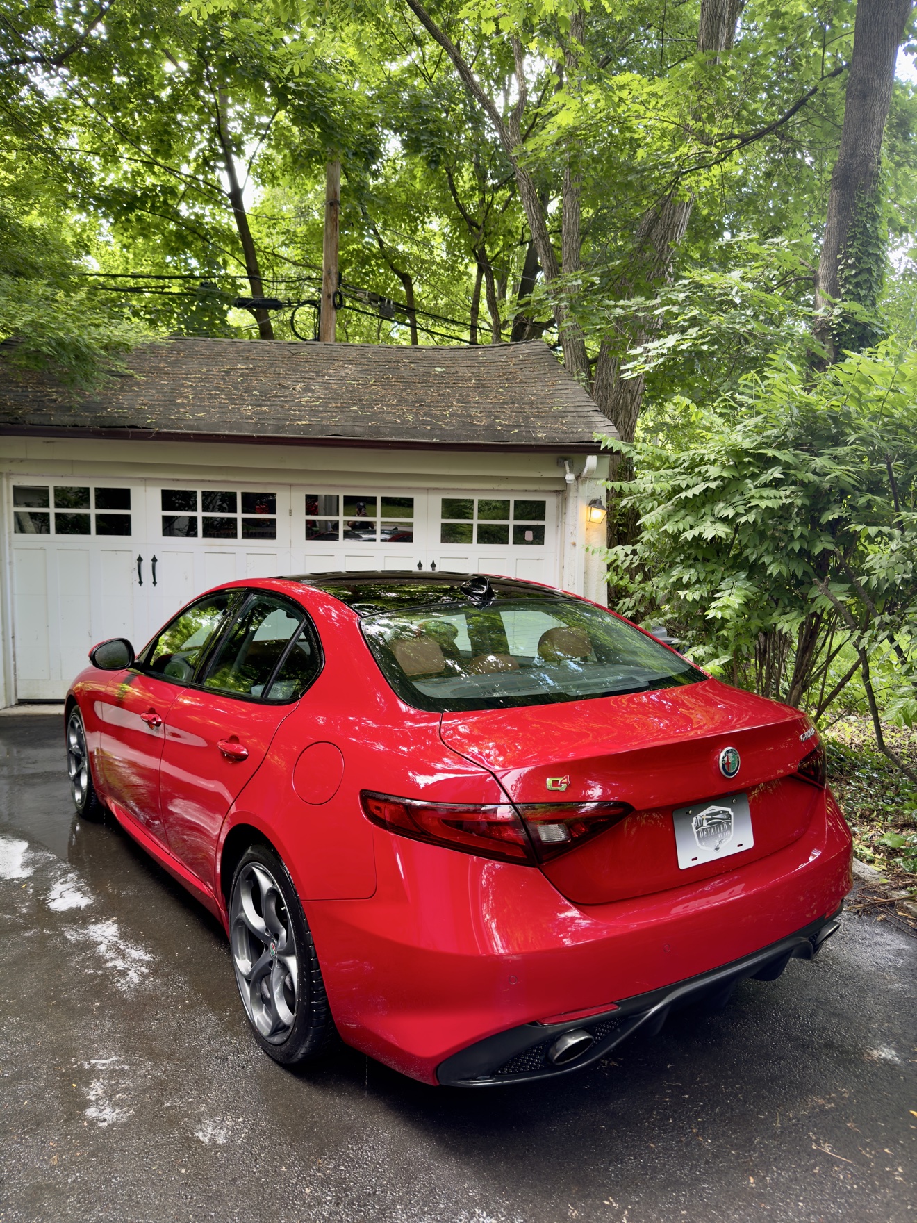 Red Alfa Romeo Giulia Q4 rear three-quarter view with Q4 badge and Detailed by Yael plate frame
