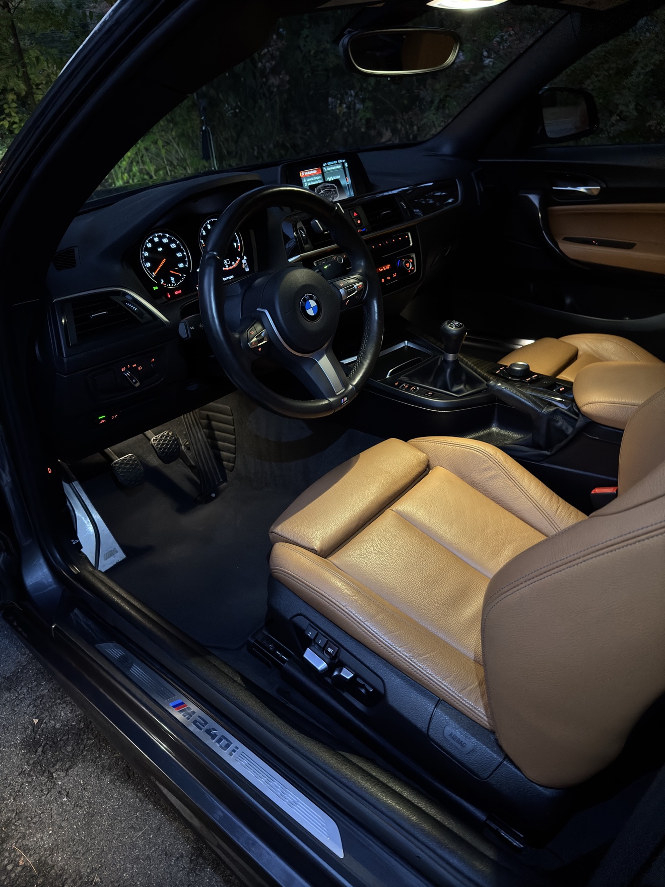 BMW M240i driver cockpit with tan leather seats and manual transmission after detailing