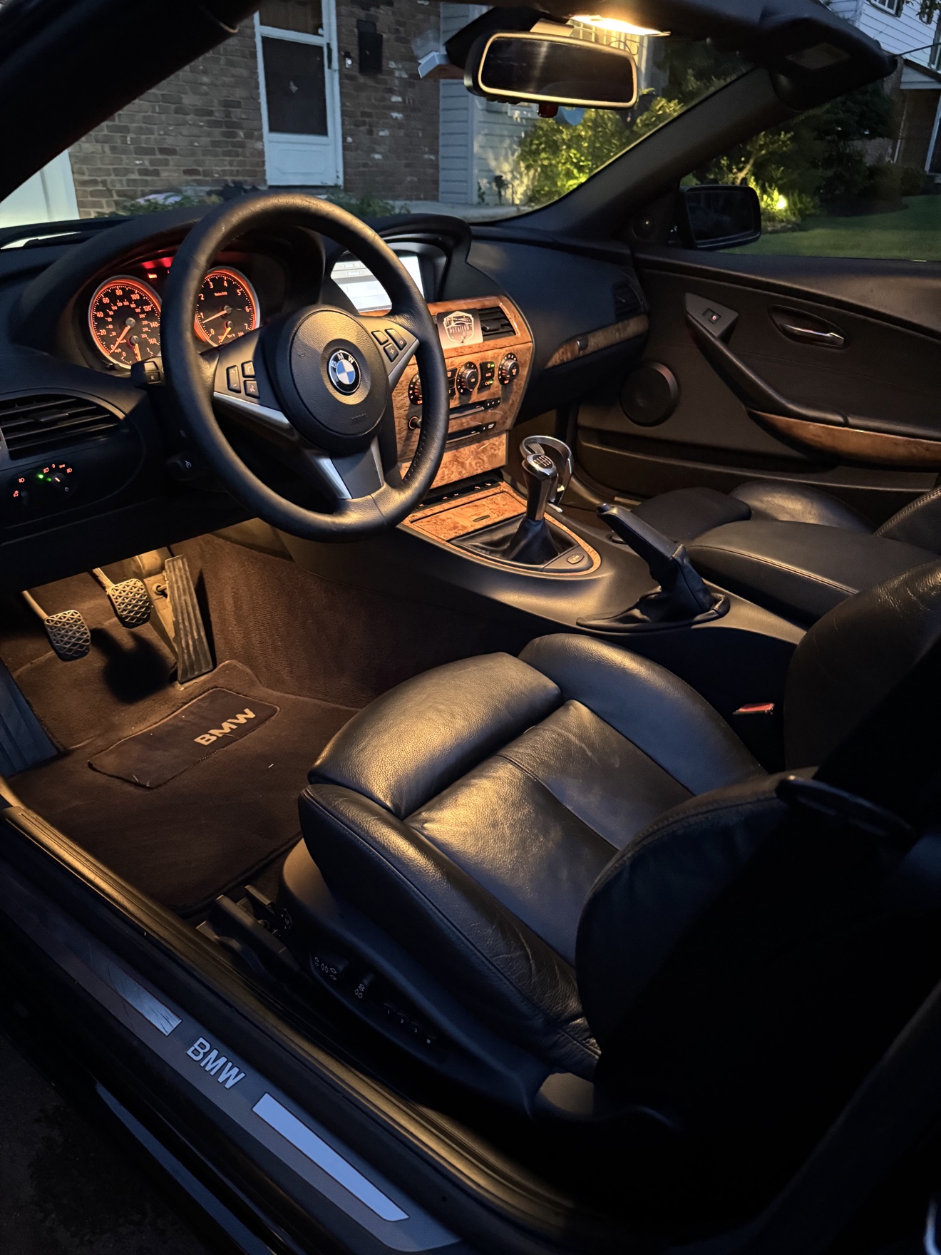 BMW 650i driver cockpit with black leather seats and manual transmission after detailing
