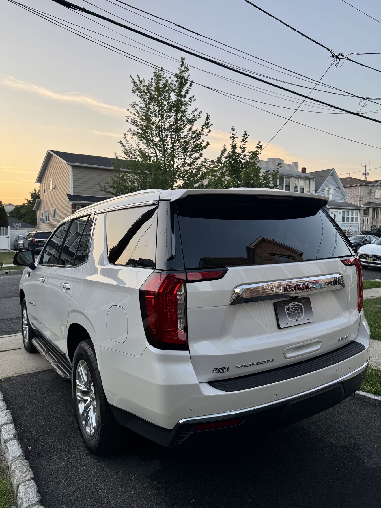 White GMC Yukon SLT rear angle view after detailing