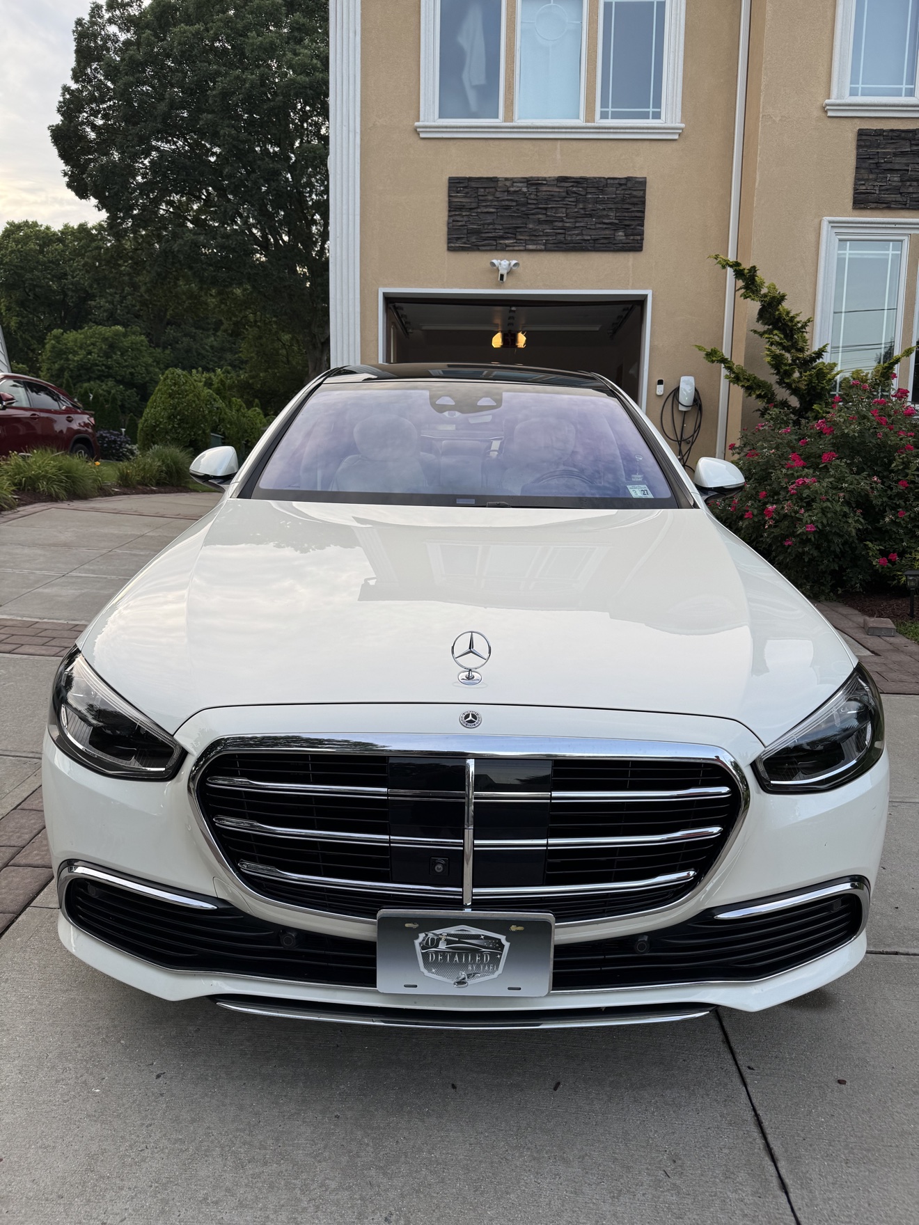 Front view of a white Mercedes-Benz S580 with Detailed by Yael plate frame