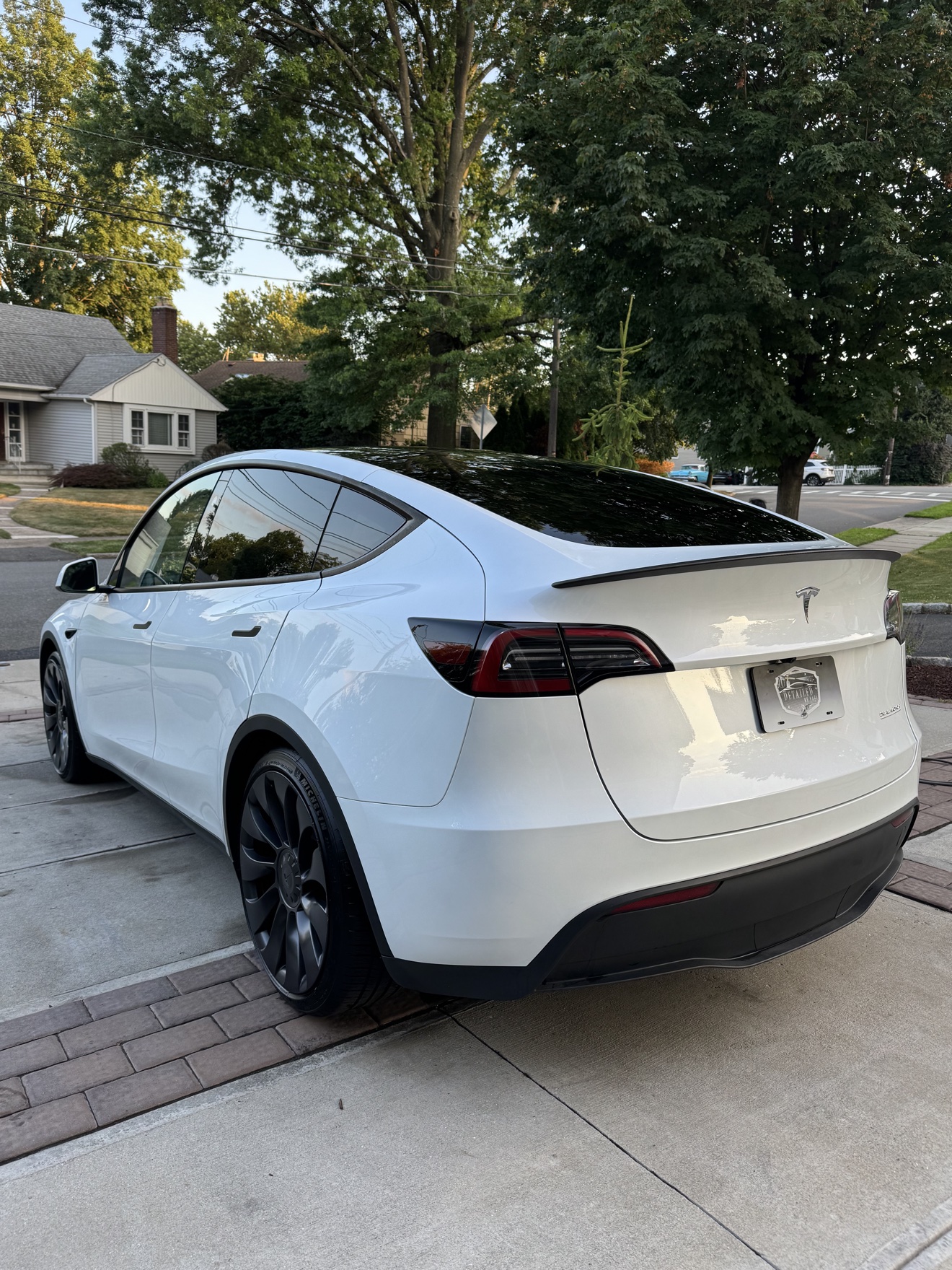 White Tesla Model Y rear three-quarter view with Dual Motor badge