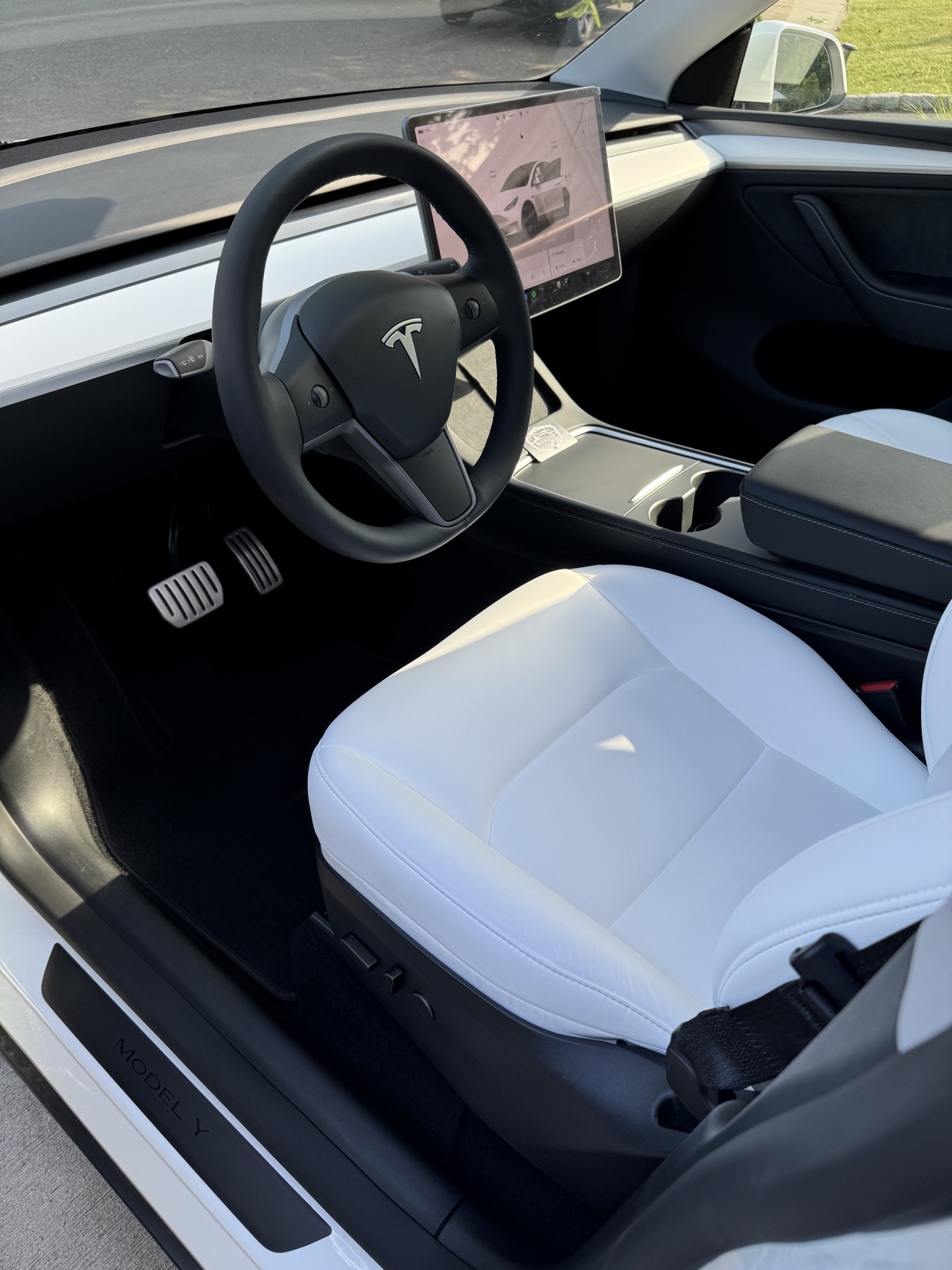 Tesla Model Y driver cockpit with MODEL Y sill plate and white leather seats