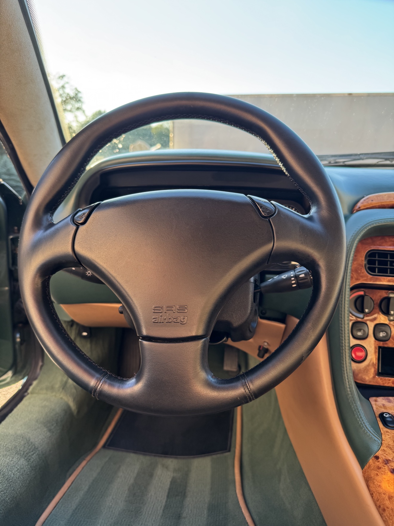 Close-up of the steering wheel and walnut dashboard in an Aston Martin DB7 Vantage