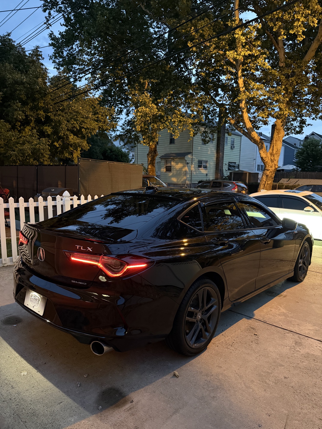 Black Acura TLX SH-AWD A-Spec rear three-quarter view with TLX and SH-AWD badges