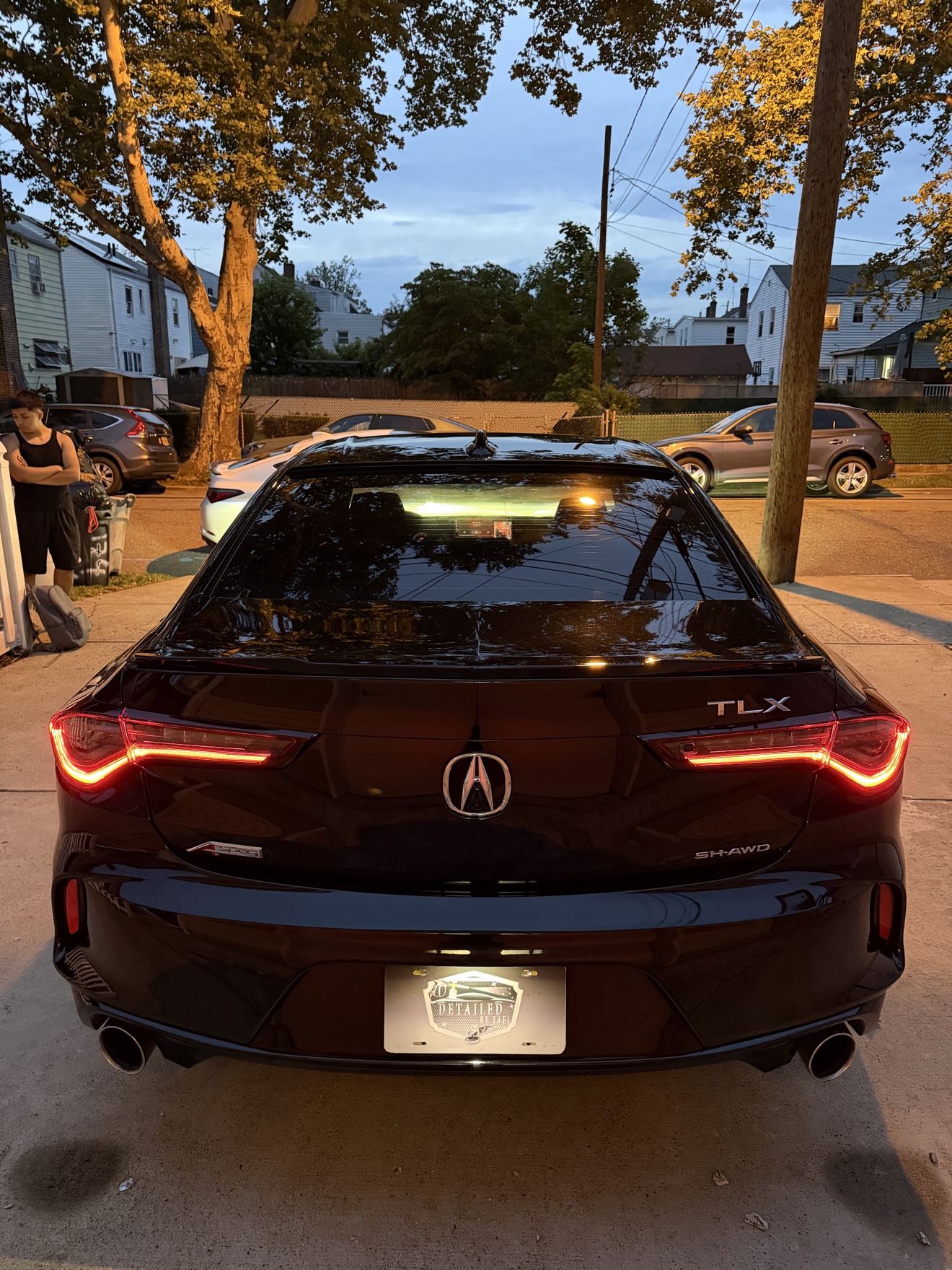 Rear view of a black Acura TLX SH-AWD A-Spec with TLX, SH-AWD and A-Spec badges and Detailed by Yael plate frame