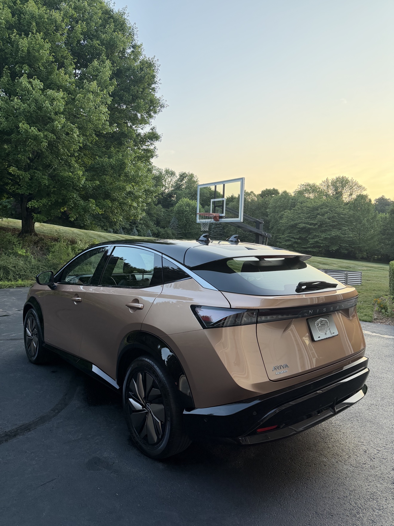 Copper Nissan Ariya rear three-quarter view with Ariya Premiere badge