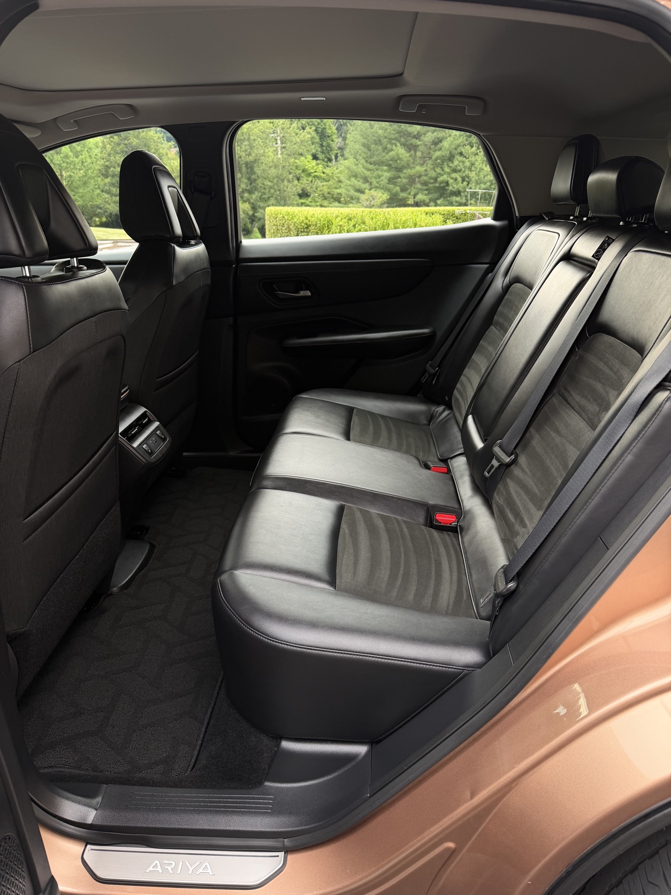 Nissan Ariya rear seats with black leather interior and Ariya sill plate