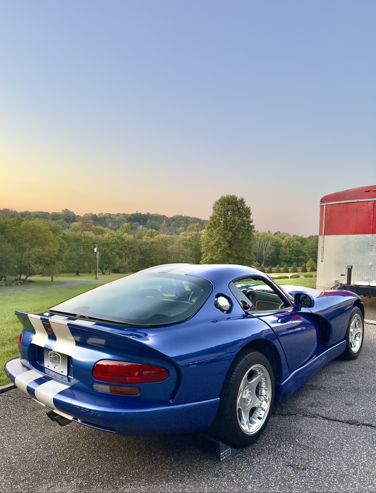 Blue Dodge Viper GTS with white stripes, rear three-quarter view at sunset
