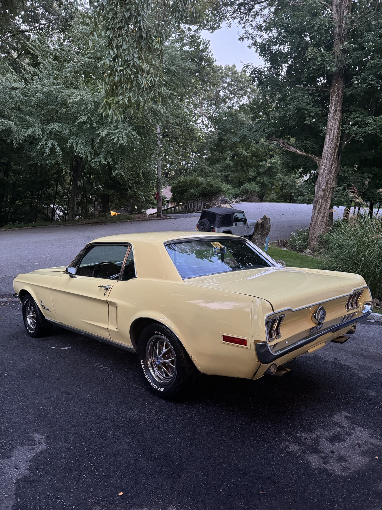 Pale yellow 1968 Ford Mustang side rear view with chrome wheels