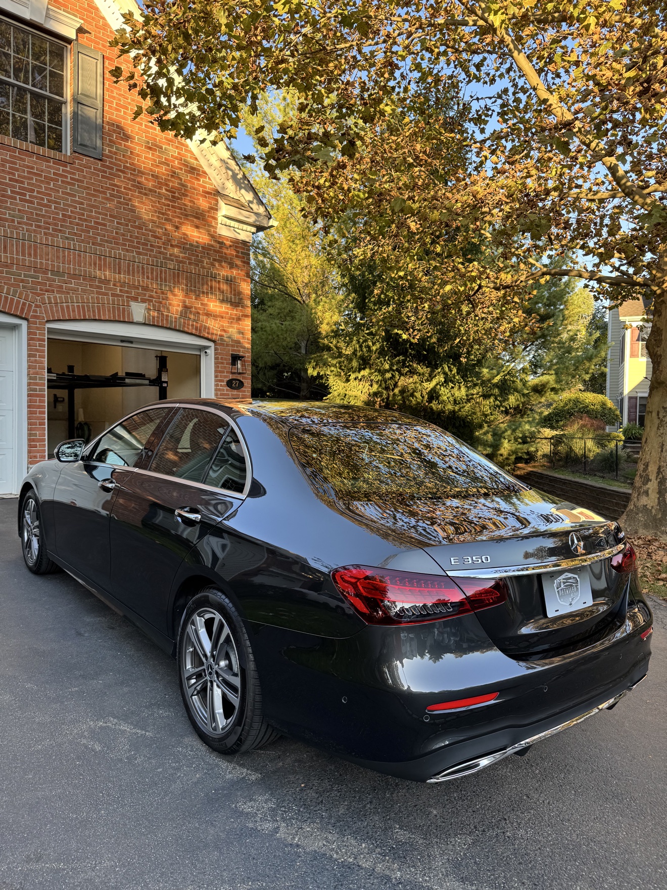 Black 2023 Mercedes-Benz E350 rear three-quarter view with gloss reflections